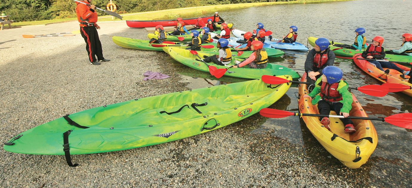 Students sitting on kayaks and listening to JCA instructor